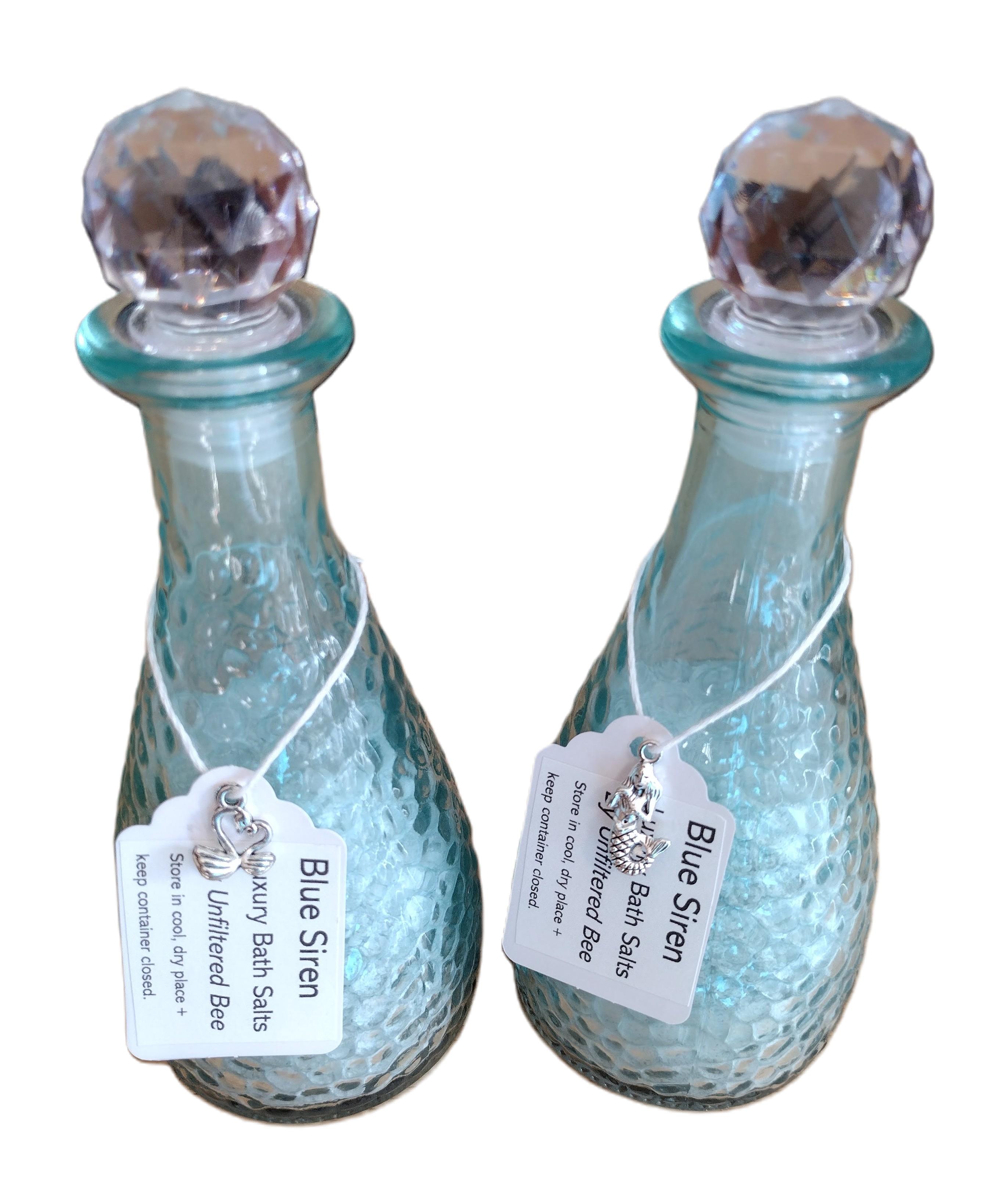 bath salts in a blue glass container with silver hanging charm