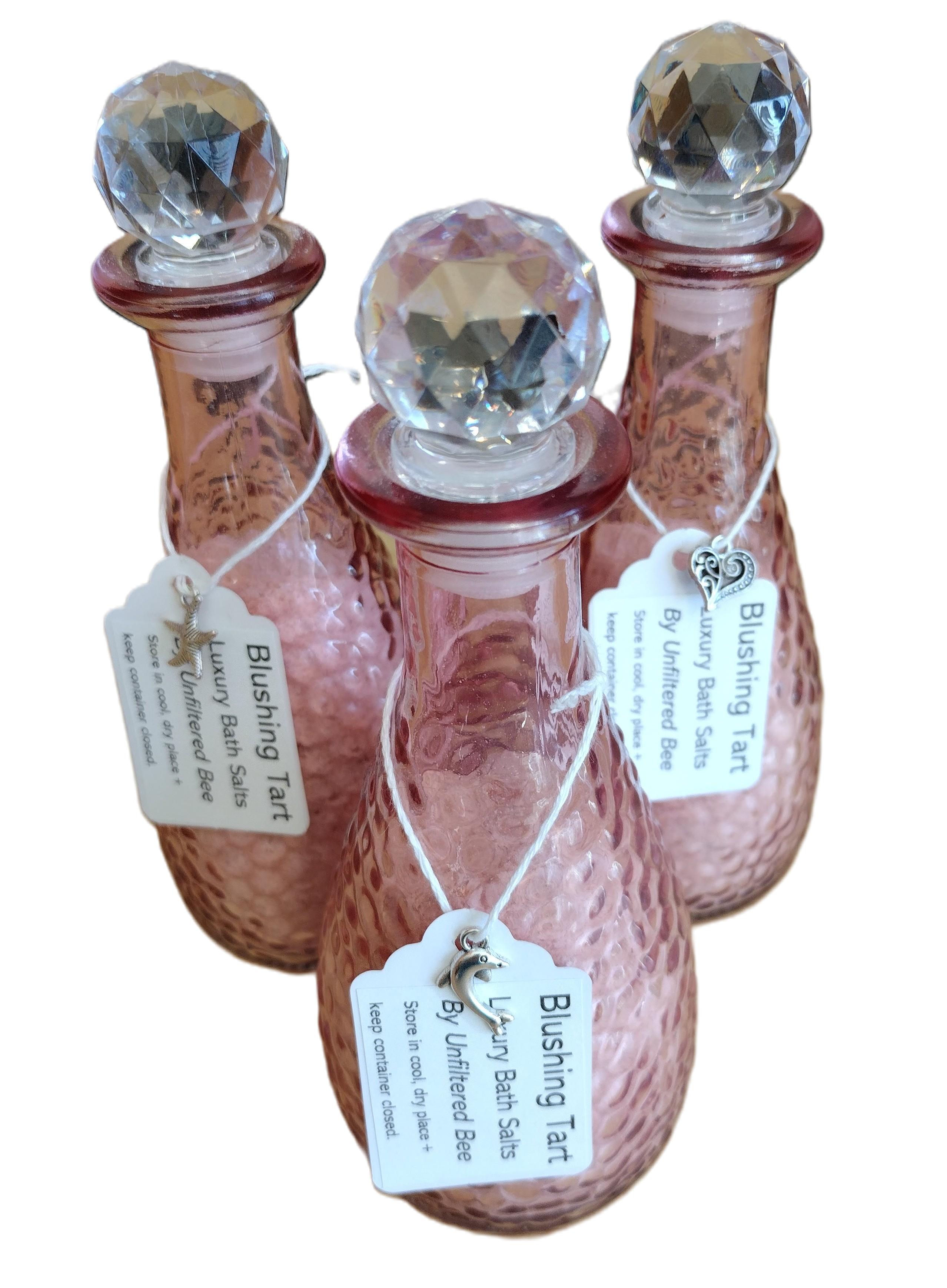 bath salts in a pink glass container with silver hanging charm