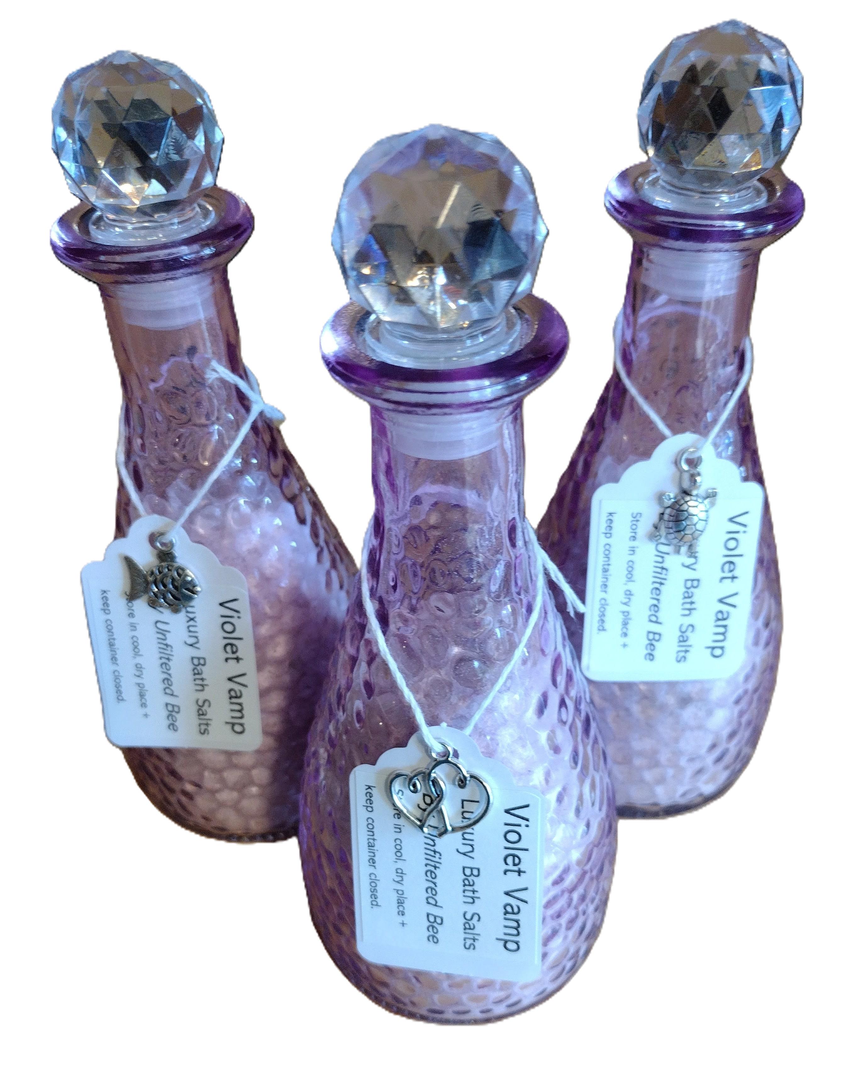 bath salts in a purple glass container with silver hanging charm